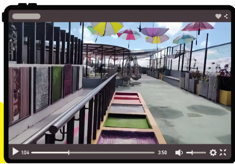 A media player interface displaying an outdoor rooftop garden featuring colorful hanging umbrellas, textured wall panels, and sensory walkway paths. A video progress bar sits at the bottom of the frame.